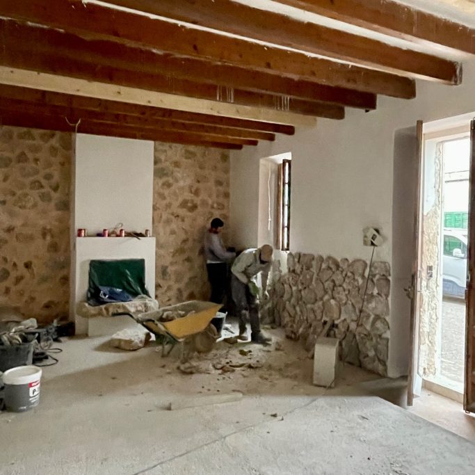 Baubegleitung Bauarbeiter renovieren einen Raum mit Steinen und Baumaterialien.