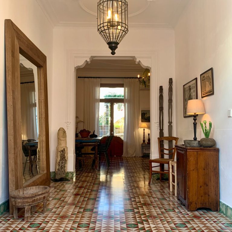 Heller Flur mit einem großen Spiegel, dekorativen Fliesen und Möbeln. Als Symbol für ein Premium Sicherheitspaket im Homeservice Mallorca