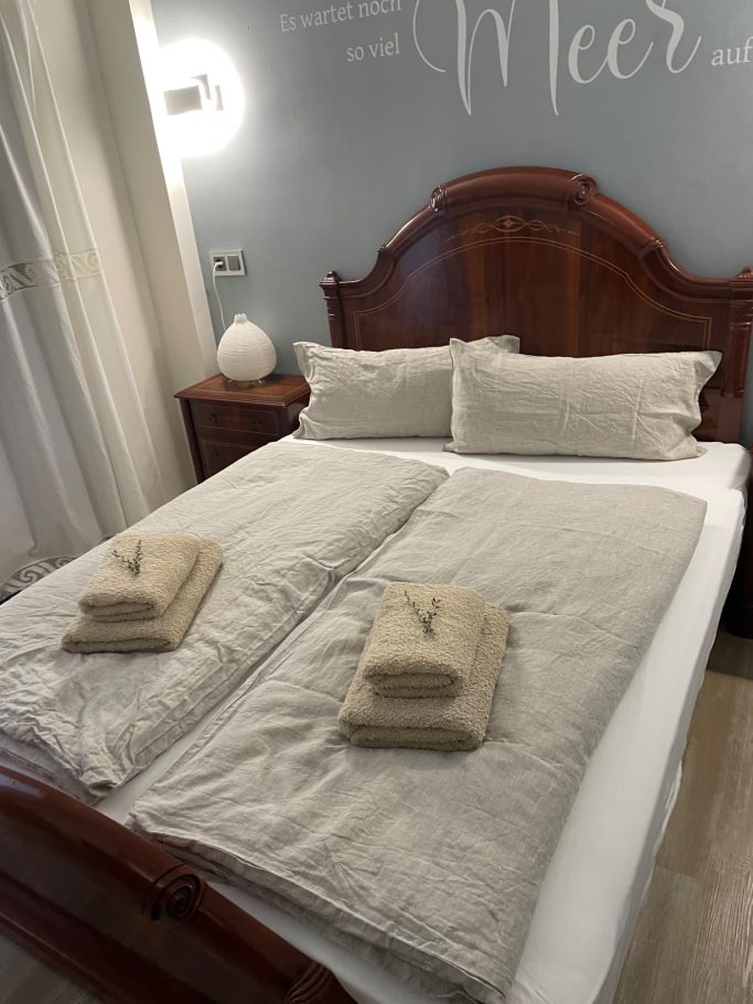 Ferienvermietung Ein gepflegtes Doppelbett mit frischen Handtüchern auf sauberen Decken.